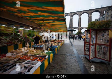 Morlaix, Bretagne, Frankreich. Der Markt und Altbauten und Viadukt. Oktober 2015 Frau im roten Mantel-Modell veröffentlicht. Stockfoto