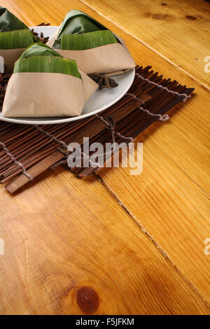 traditionelle frische malaysische Nasi Lemak vollgepackt mit Bananenblatt in Holz Hintergrund Stockfoto