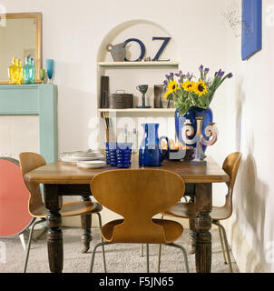 Arne Jacobsen Stil Stühle am Tisch mit blau Glas in einer weißen neunziger Jahre Esszimmer Stockfoto