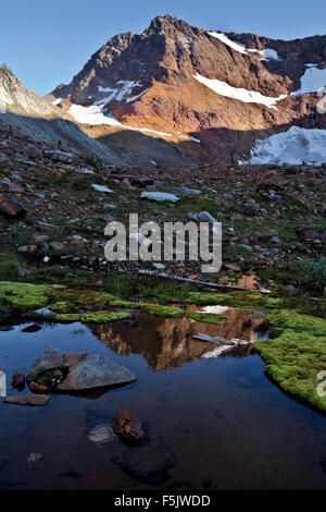 WASHINGTON - Red Mountain in einen kleinen Teich im oberen Lyman Seen Becken in den Glacier Peak Wilderness widerspiegelt. Stockfoto