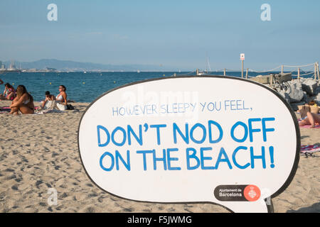 Warnung vor Sonnenbrand, mit Sonnencreme, UV, Gefahren, nicht schlafen am Strand von Barceloneta Strand, Stadtstrand Barcelona, Katalonien, Spanien. Stockfoto