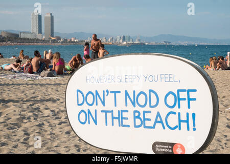 Warnung vor Sonnenbrand, mit Sonnencreme, UV, Gefahren, nicht schlafen am Strand von Barceloneta Strand, Stadtstrand Barcelona, Katalonien, Spanien. Stockfoto