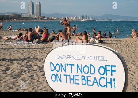 Warnung vor Sonnenbrand, mit Sonnencreme, UV, Gefahren, nicht schlafen am Strand von Barceloneta Strand, Stadtstrand Barcelona, Katalonien, Spanien. Stockfoto