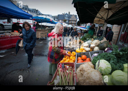 Morlaix, Bretagne, Frankreich. Der Markt und alten Gebäuden. Oktober 2015 Frau im roten Mantel-Modell veröffentlicht. Stockfoto