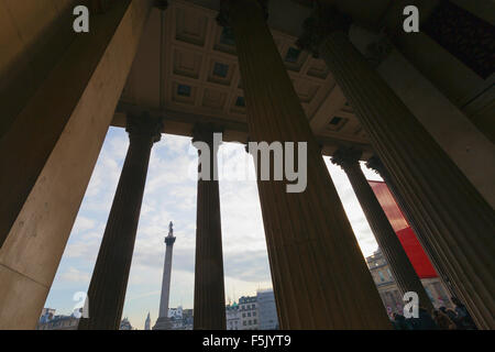 Die Nelsonsäule betrachtet durch die Säulen am Eingang in die National Gallery Stockfoto