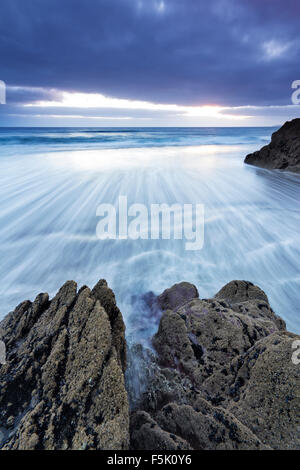 Gewitterwolken über einem zurückweichenden Flut an Freathy Strand Whitsand Bay Cornwall UK Stockfoto