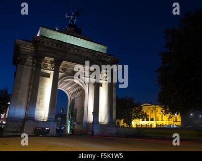 Radfahrer fahren durch Wellington Arch am Hyde Park Corner in London bei Nacht Stockfoto