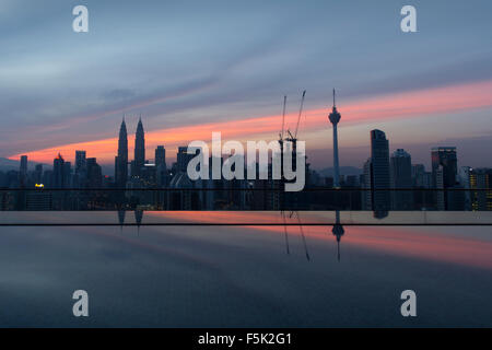 Skyline von Kuala Lumpur bei Sonnenaufgang mit einem Luxus-Pool im Vordergrund Stockfoto