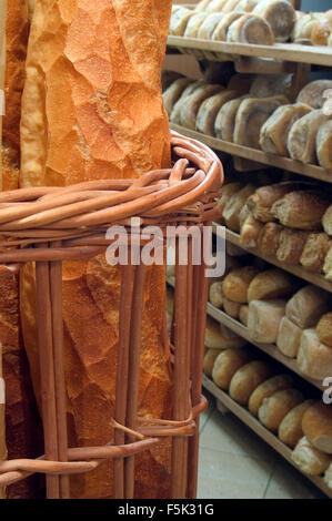 Baguettes und Regale mit Brote frisch gebackenes Brot auf dem Display in Bäckerei Stockfoto