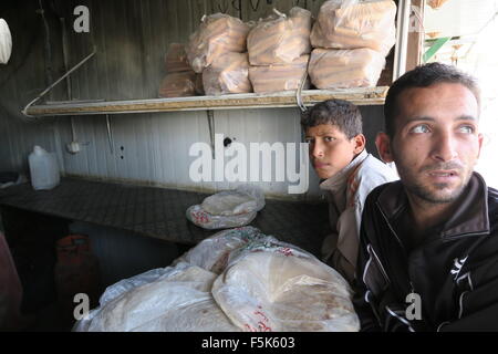 Zwei syrische Flüchtlinge kaufen Brot im Flüchtlingslager Zaatari in Jordanien und befürchten immer genug zu essen zu überwintern. Stockfoto