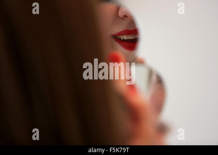 Junge hübsche Mädchen bewerben roten Lippenstift auf die Lippen in Worthing, West Sussex, UK. Stockfoto