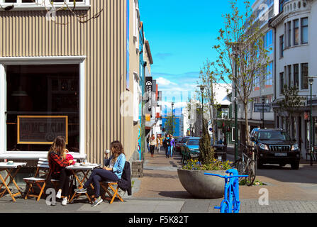 Junge Frauen trinken in einem Straßencafé in der Sonne Reykjavik Island Stockfoto