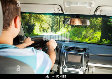 Fahren Mann in Auto mit wunderschönen Waldblick Stockfoto