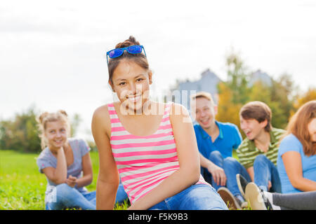 Asiatische Mädchen und Freunde sitzen zusammen im park Stockfoto