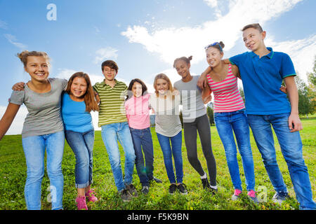 Lächelnd Vielfalt Freunde stehen auf dem Rasen in Zeile Stockfoto