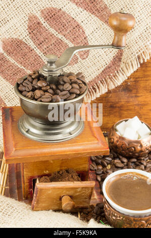 Kaffee in verschiedenen Formen rund um Oldtimer Kaffeemühle. Gemahlenen Kaffee in einer Schublade Stockfoto