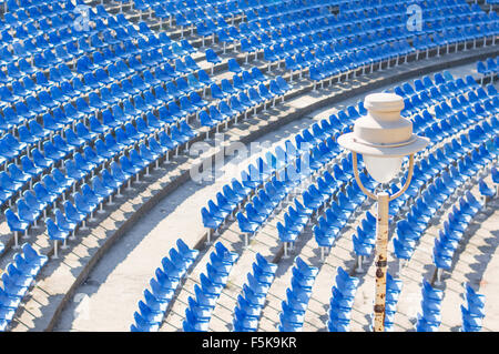 Glühbirne in einem leeren Amphitheater mit blauen Stühlen Hall am Tag Stockfoto