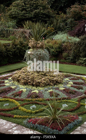 Phormium gepflanzt in Stein Urne in der Mitte eines Teppichs gepflanzt jährliche Bett Stockfoto