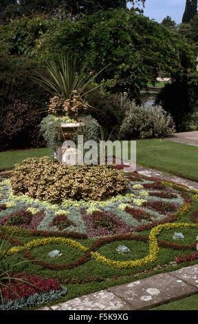 Phormium gepflanzt in Stein Urne in der Mitte eines Teppichs gepflanzt jährliche Bett Stockfoto