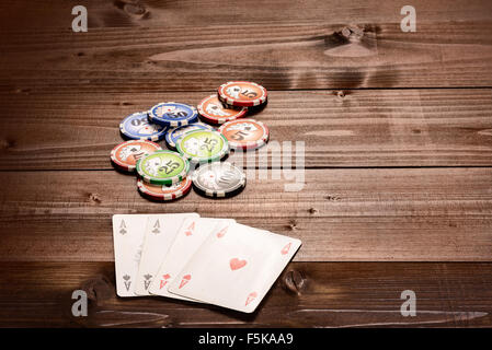 Vier Asse und Chips, Vintage Poker Spiel Spielkarten auf einem Holztisch Stockfoto