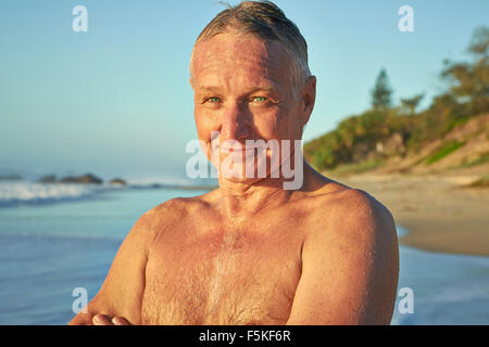 Reifen Alter Mann lächelnd nach dem Schwimmen im Ozean Stockfoto