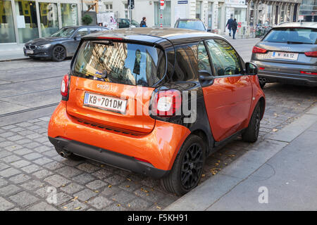 Wien, Österreich - 4. November 2015: Leuchtend rotes Smart Fortwo W453 Auto steht auf der Stadtansicht Straße, hinten Stockfoto