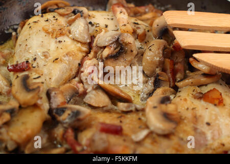 Gebratenes Huhn mit Pilzen und Speck kochen Stockfoto