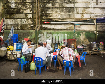 Yangon, Yangon Division, Myanmar. 6. November 2015. Männer Essen und trinken Tee in einem informellen Tee-Shop auf einer Straße in Yangon. Einige Ökonomen halte Myanmars Schattenwirtschaft größer als die formale Wirtschaft. Viele Menschen sind selbständige in Bargeld nur Unternehmen wie Suppen, gelegentliche Arbeit und Arbeit, Betel zu verkaufen, oder Arbeiten aus tragbaren Straßenständen, Dinge zu tun wie Gepäck Reparatur. Trotz der Reformen in Myanmar und die Expansion der Wirtschaft leben die meisten Menschen in der informellen Wirtschaft. Während einer Pressekonferenz in dieser Woche birmanischen Oppositionsführerin Aung San Suu Kyi sagte, "eine große Majo Stockfoto
