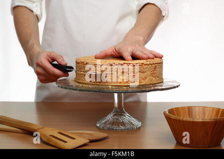 Schneiden Kuchen auf Layern. Herstellung von Victoria Schwammkuchen. Serie. Stockfoto