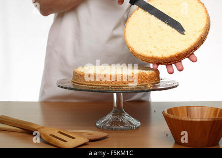 Schneiden Kuchen auf Layern. Herstellung von Victoria Schwammkuchen. Serie. Stockfoto