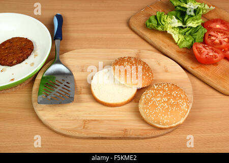Zutaten für die Herstellung: Tomaten, Salat, Brötchen, Patty. Hamburger machen. Serie. 1/15. Stockfoto