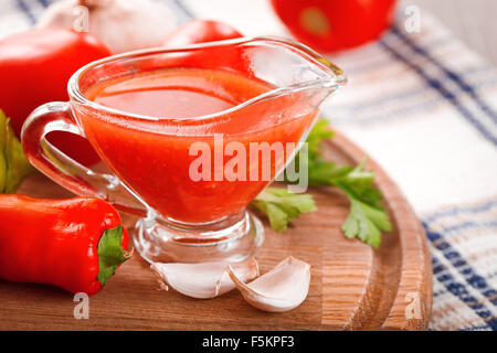 Tomatensauce in eine Sauciere Glas auf dem Tisch Stockfoto