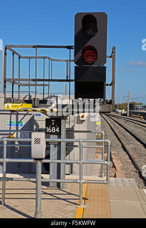 LED-Signal auf Plattform zeigt einen roten Aspekt mit Typenschild unten und ein Telefon in einer Box auf dem Geländer Stockfoto