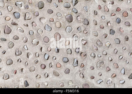 Echten Steinen in Betonmauer, natürliche abstrakten Hintergrund oder Textur. Stockfoto