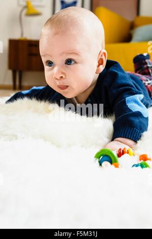 Baby Junge kriecht auf einem Teppich Stockfoto