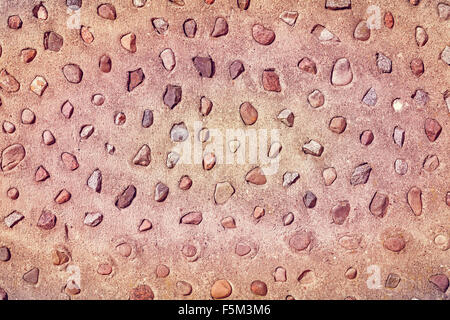 Echten Steinen in Betonmauer, natürliche abstrakten Hintergrund oder Textur. Stockfoto