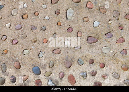 Echten Steinen in Betonmauer, natürliche abstrakten Hintergrund oder Textur. Stockfoto