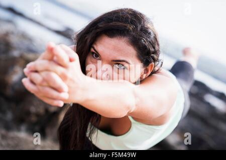 Nahaufnahme von Frau am Küste praktizieren Yoga, balancieren auf einem Bein Stockfoto