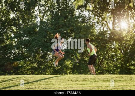 Junger Mann und Frau dabei springen Training im park Stockfoto