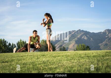 Junger Mann und Frau tun Aufwärm-Training im park Stockfoto