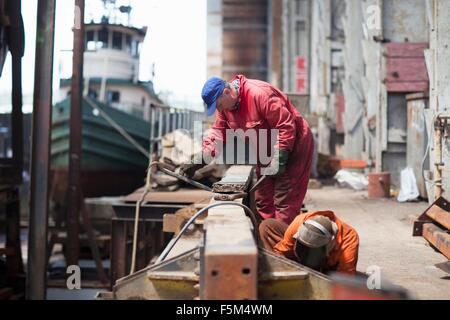 Arbeitnehmer, die Wartungsarbeiten in Werft Werkstatt Stockfoto