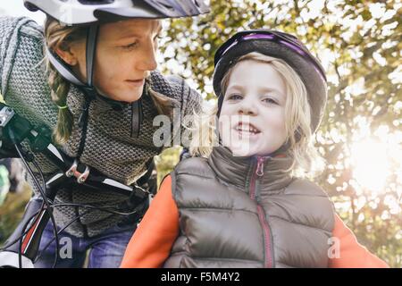 Niedrigen Winkel Ansicht von Mutter und Tochter auf Fahrrädern, Helmen, Blick in die Kamera Stockfoto