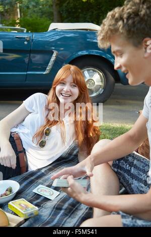 Junges Paar mit Cabrio Spielkarten auf der Picknickdecke Stockfoto