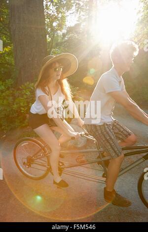 Junges Paar auf Tandem Radfahren radeln Sie entlang Landstraße Stockfoto