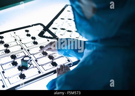 Arbeitnehmerin Inspektion Flex-Schaltung auf Leuchtkasten in flexible Elektronik Fabrik Reinraum Stockfoto