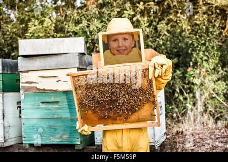 Porträt des jungen im Halterahmen Bienenstock voller Bienen Imker-Kleid Stockfoto