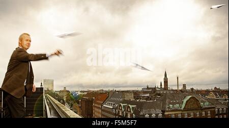 Geschäftsmann, fliegende Papierflieger auf Dach, Stadt von Kopenhagen, Dänemark Stockfoto