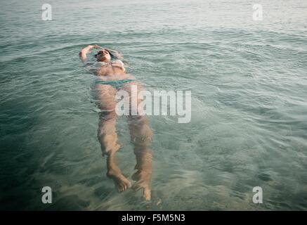 Junge Frau mit Bikini im Meer schwimmende Stockfoto