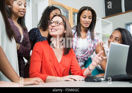 Weibliche Lehrer, Schülerinnen und Schüler zu erklären, auf laptop Stockfoto