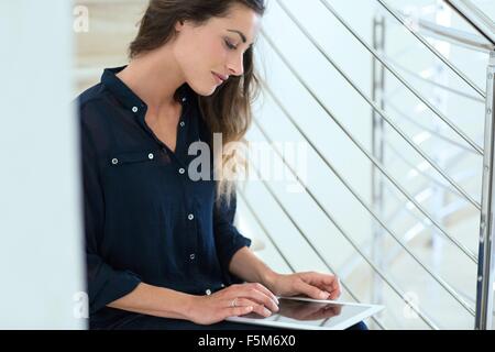 Junge Geschäftsfrau mit digital-Tablette auf Büro-Treppe Stockfoto